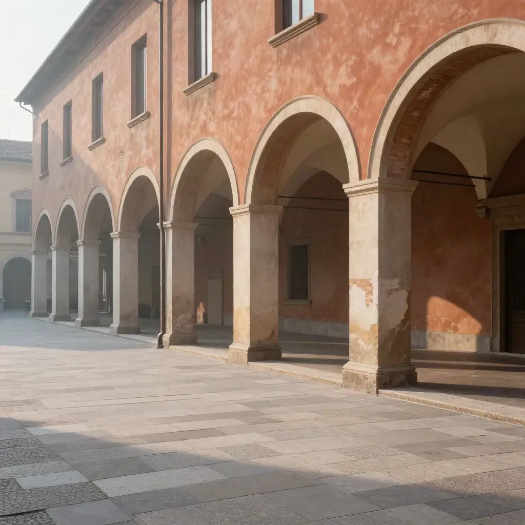 Portici di Bologna e mura in cotto tra nebbia calda e selciato chiaro